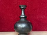 deux vases posés sur une table, avec un mur rouge en arrière-plan