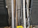 une pile de skis et de bâtons de ski devant la porte d'un garage