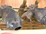 two fish on a shelf next to a bottle of wine