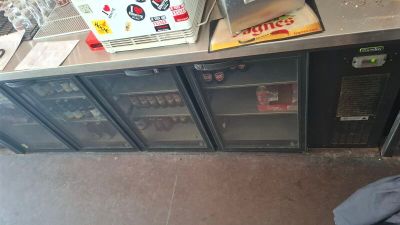 a refrigerator with a bunch of bottles on top of it