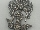 une image représentant une broche ornée d'une fleur et de feuilles