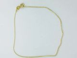 a gold chain bracelet with a heart charm on a white background