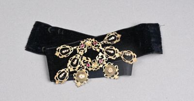 une image représentant une ceinture noire ornée de chaînes en or et de bijoux