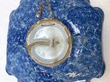 a blue plate with a gold rim hanging on a wall