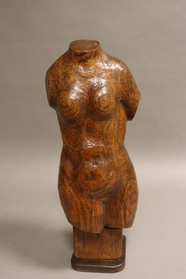 une photo représentant une sculpture en bois représentant un torse féminin posé sur un socle