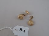 two pairs of gold plated earrings and a tag on a white surface