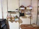 a room with a table, shelves, and a refrigerator