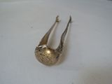 a silver spoon and spoon rest on a white surface