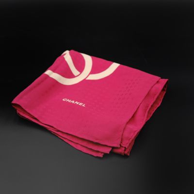 pink towel with white logo on it on a black surface