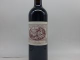 la bouteille de vin rouge est posée sur une surface blanche