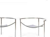pair of chrome steel lounge chairs with white leather seats
