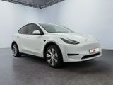 a white tesla model y parked in a white room