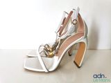 pair of white high heeled shoes with gold chains on them