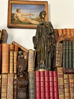 a statue of a woman sitting on top of a pile of books