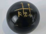 a black ball with gold writing on it