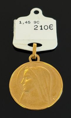 un gros plan d'une médaille d'or à laquelle est attachée une étiquette