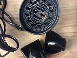 a black blow dryer sitting on top of a wooden table