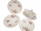three plates and a bowl with flowers on them on a white surface