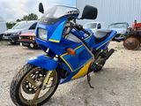 a blue and yellow motorcycle parked in front of a building