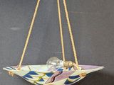 a glass bowl hanging from a rope on a wall