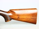an old wooden rifle with a wooden handle on a white surface