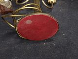 a candle holder with a red stone on it