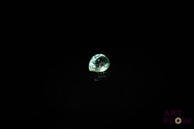 gros plan d'un diamant vert sur une surface noire