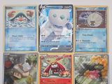 Plusieurs cartes Pokémon sont accrochées au mur d'une pièce.
