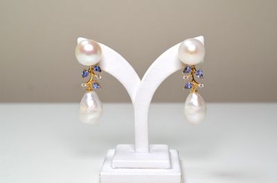 paire de boucles d'oreilles en perles et tanzanite, présentée sur un présentoir blanc