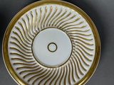 two white and gold plates with gold designs on them