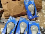 three packages of light bulbs sitting on top of a cardboard box