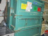 a large green box sitting in a garage next to a pile of boxes