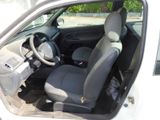 the interior of a small white car with black seats and a steering wheel