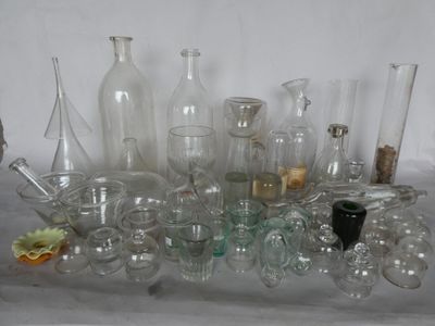 de nombreux vases et bouteilles en verre de toutes sortes posés sur une table