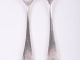 two silver spoons and a fork on a white surface