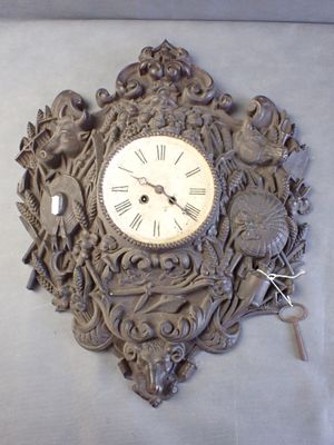 une horloge accrochée au mur, avec une clé à l'intérieur