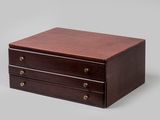a small wooden box with three drawers on top of it