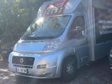 a silver van parked in a parking lot with trees in the background