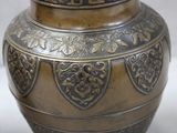 a large metal vase that is sitting on a table