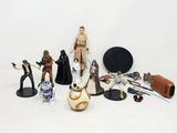 Des figurines et des personnages de « Star Wars » sont disposés sur une surface blanche
