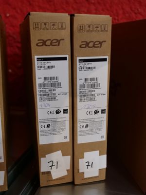 trois cartons contenant des ordinateurs portables Acer posés sur une table