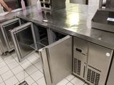 stainless steel counter top in a commercial kitchen with a woman standing in the background