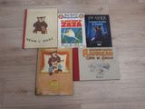 several children ' s books are lined up on a wooden floor