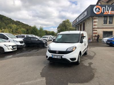 La camionnette blanche est garée devant un grand immeuble.