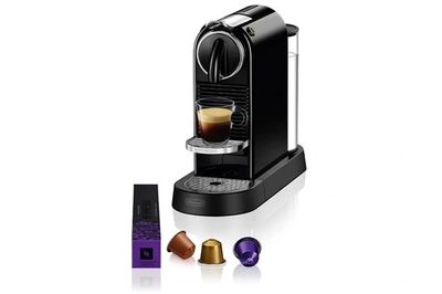 a black coffee machine with a cup of coffee next to it