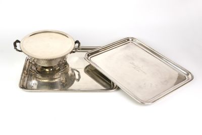 deux plateaux en argent et un plateau muni d'un couvercle, posés sur une surface blanche