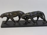figurine en bronze représentant deux guépards marchant sur un socle noir