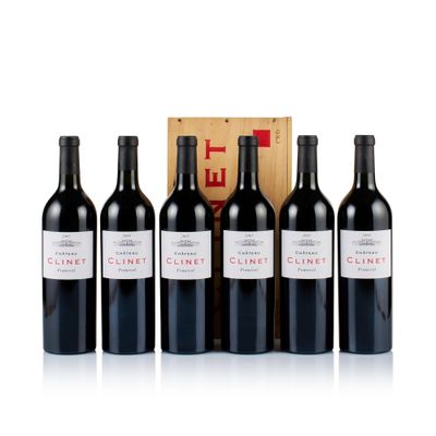 quatre bouteilles de vin rouge devant une caisse en bois