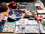 une table sur laquelle sont disposés de nombreux objets, recouverte d'une nappe à carreaux noirs et blancs
