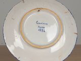 a white plate with blue trim on a wooden table